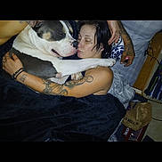 Duece joined the competition — help win amazing prizes! dog, person, tattoo, bed, blanket, cuddle, indoor, affection, black_hair, casual, resting, snuggle, comfort, pet, cozy, relaxation, human, animal, love, home