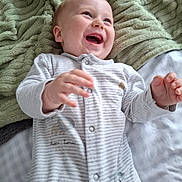 Arlo joined the competition — help win amazing prizes! baby, infant, smiling, happy, lying_down, blanket, soft_texture, onesie, clothing, cute, child, face, hands, portrait, indoor, cozy, joyful, young_child, light, warm