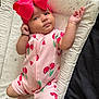 Kiara is registered to the contest to win money with this photo: baby, child, infant, headband, bow, pink_clothing, cherry_pattern, onesie, lying_down, changing_pad, patterned_pad, raised_arm, curious_expression, indoors, soft_lighting, cute, small_person, human, baby_girl, sleepwear