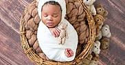 Moneii James joined the competition — help win amazing prizes! baby, newborn, sleeping, wrapped, blanket, basket, teddy_bear, stuffed_animal, cute, hat, infant, peaceful, soft, child, portrait, wooden_floor, cozy, resting, adorable, indoor
