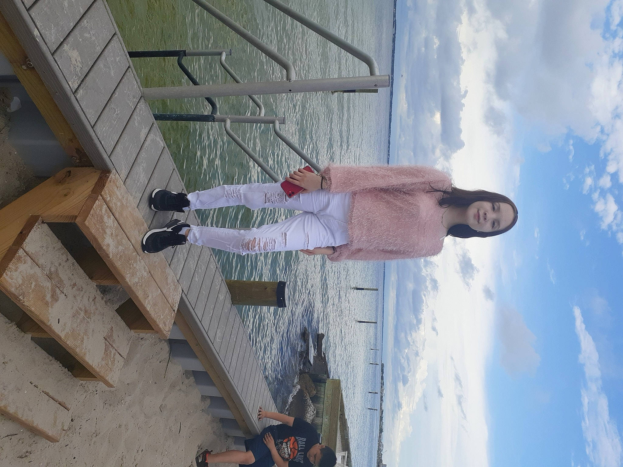 Brianna joined the competition — help win amazing prizes! cloud, composite_material, concrete, daytime, facade, hat, joy, leisure, line, outdoor_shoe, person, recreation, shadow, sky, walking_shoe, wall, wood