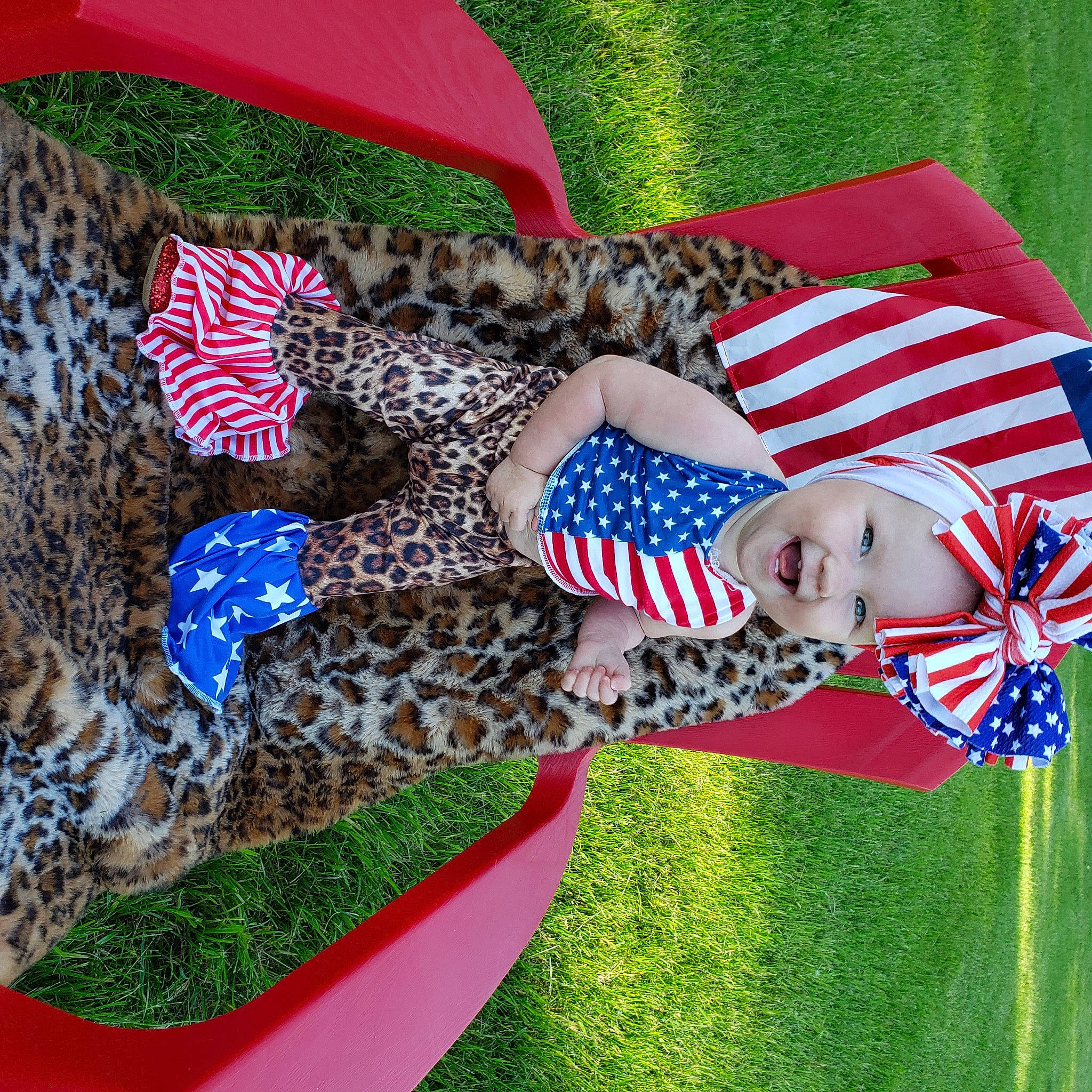 Mckenzie is registered to the contest to win money with this photo: electric_blue, event, flag, flag_day_usa, flag_of_the_united_states, grass, hat, headgear, headwear, holiday, linens, pattern, person, red, tree
