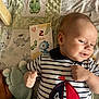 Ethan a rejoint le concours — aidez-le/la à gagner de superbes lots ! baby, infant, striped_shirt, sailboat_patch, knitted_toy, blanket, dinosaur_pattern, milestone_card, 2_months, smiling, lying_down, cute, child, soft_toys, home, portrait, baby_clothes, hand, face, childhood