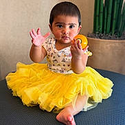 Tiara Chowdary joined the competition — help win amazing prizes! toddler, child, yellow_tutu, hello_kitty, orange_ball, curious_expression, sitting, indoor, plant, bamboo, cute, baby, portrait, clothing, toy, face, hand, foot, furniture, soft_lighting