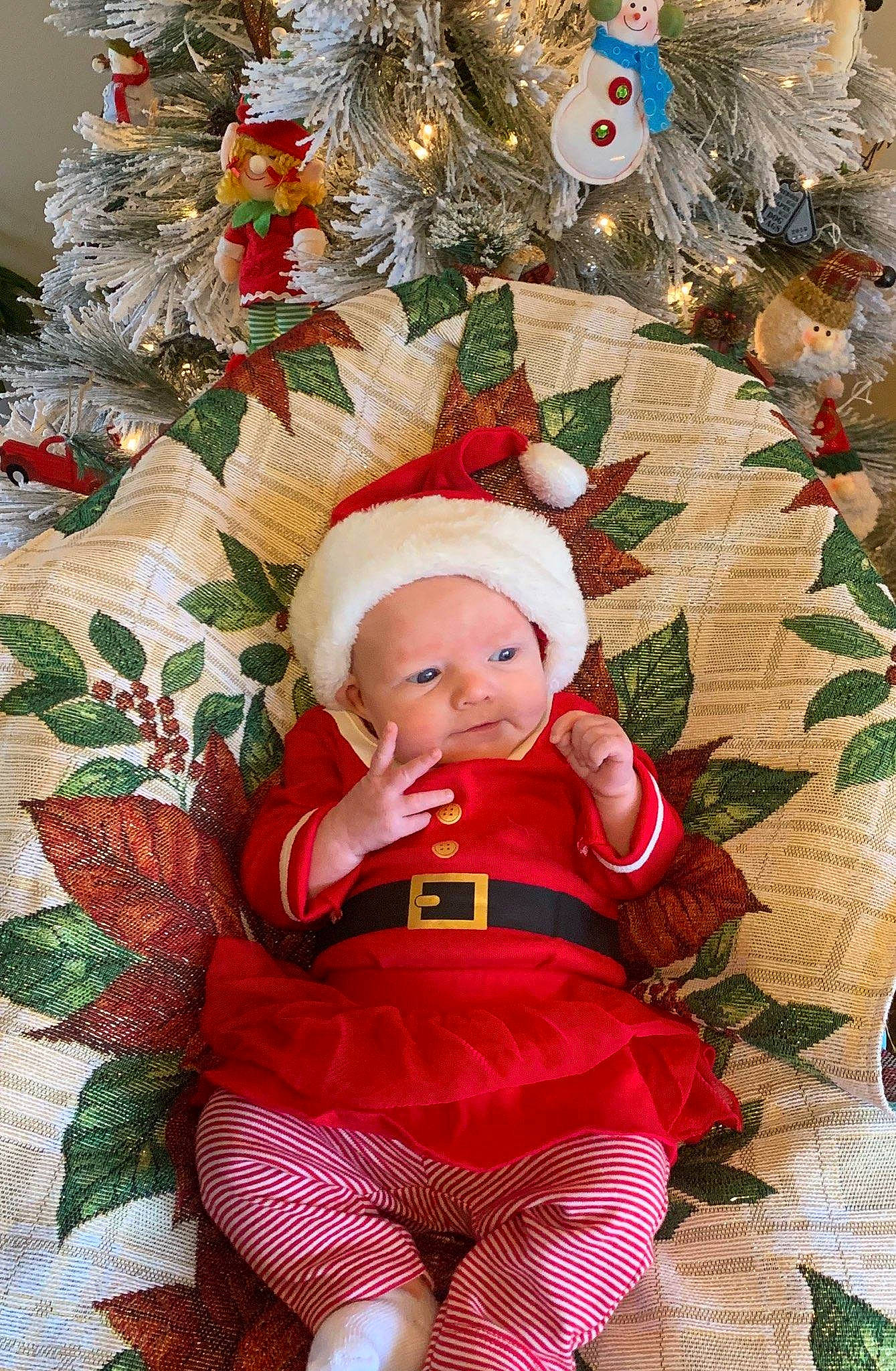 Mercy is registered to the contest to win money with this photo: baby, child, christmas, christmas_decoration, christmas_eve, christmas_ornament, christmas_tree, conifer, event, fictional_character, fir, holiday, holiday_ornament, interior_design, person, pine_family, plant, toddler, tree