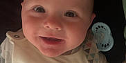 Mateo is registered to the contest to win money with this photo: accessory, baby, baby_clothes, child, closeup, clothing, cute, face, fish, happy, indoors, infant, lying_down, pacifier, person, portrait, sailboat, smiling, striped, young