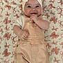 Toni-Louise is registered to the contest to win money with this photo: baby, infant, smiling, headband, overalls, blanket, pattern, cute, happy, child, portrait, clothing, soft, laying, playful, hands, face, indoors, person, young