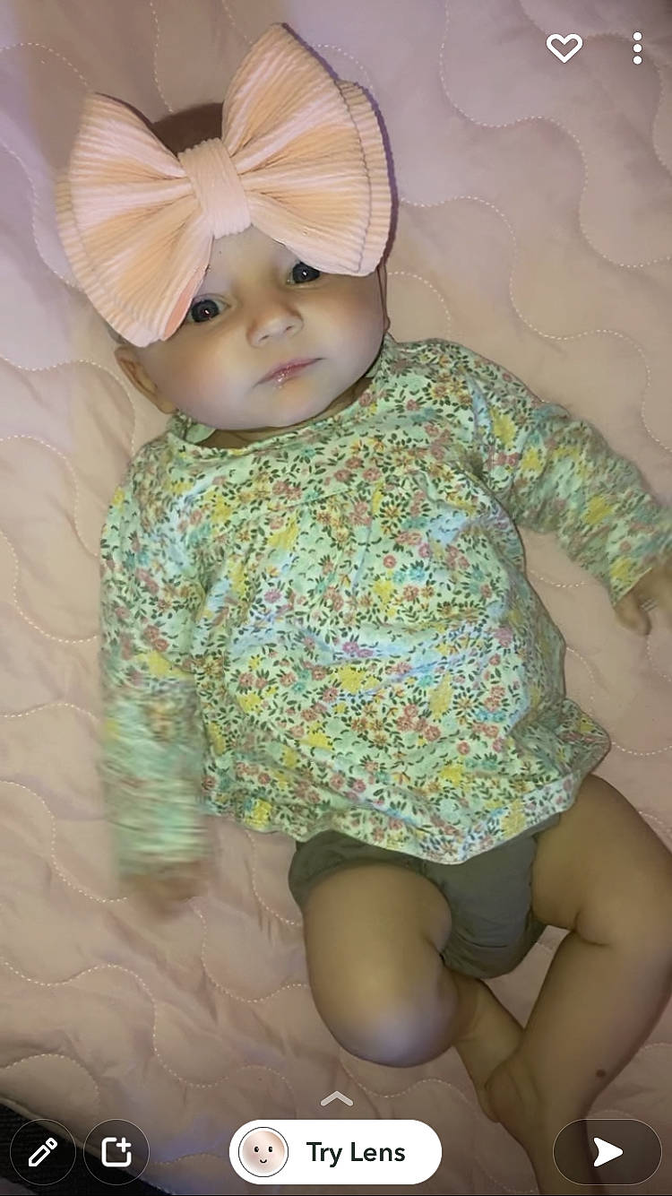 Claire joined the competition — help win amazing prizes! baby, baby_toddler_clothing, cap, child, grass, headpiece, headwear, human_body, human_leg, iris, linens, organ, pattern, person, pink, sitting, skin, sleeve, textile, thigh