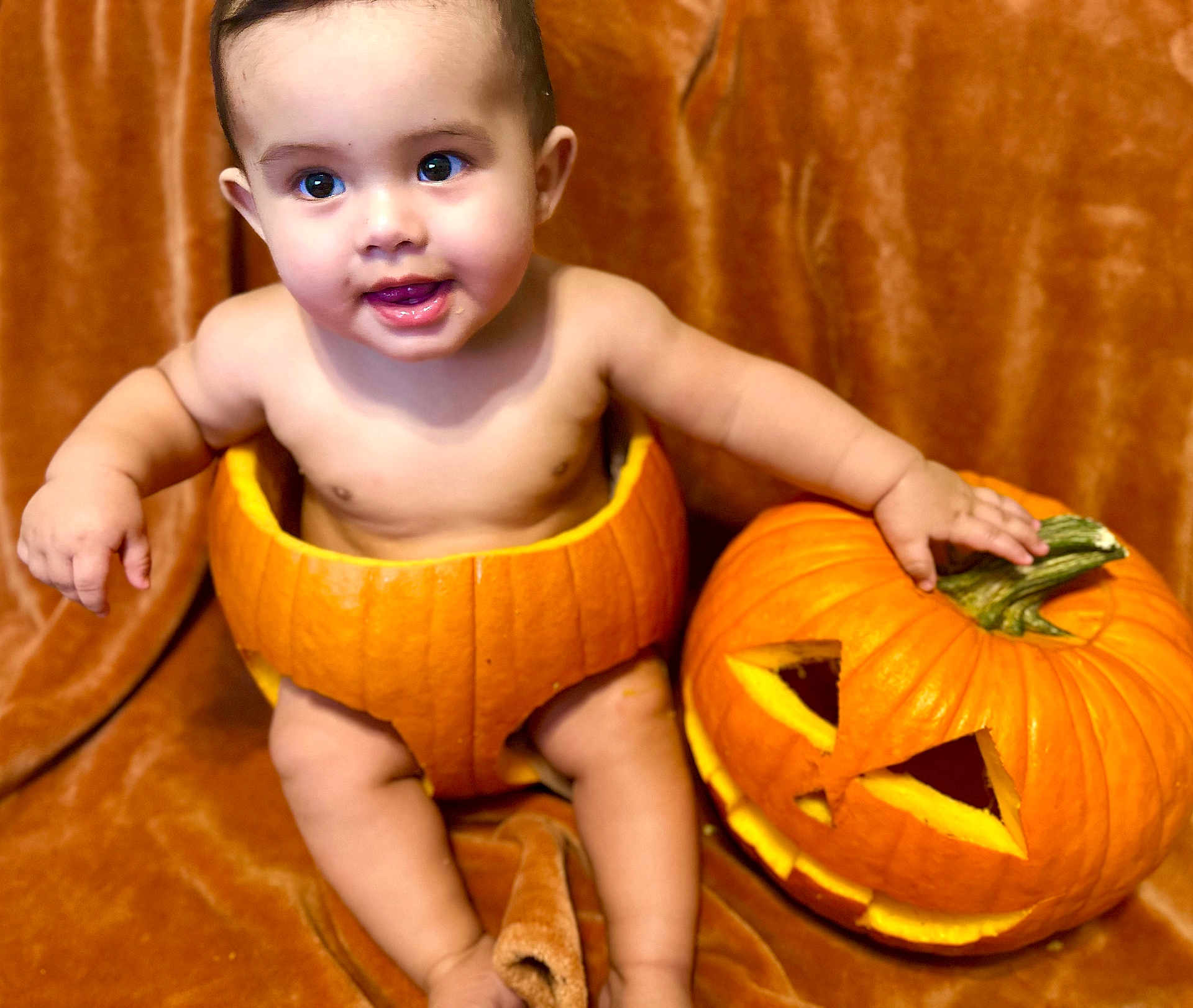 Eric is registered to the contest to win money with this photo: baby, child, pumpkin, carved_pumpkin, halloween, orange, cute, smiling, face, skin, sitting, holiday, festive, background, cheerful, indoors, autumn, decoration, playful, costume