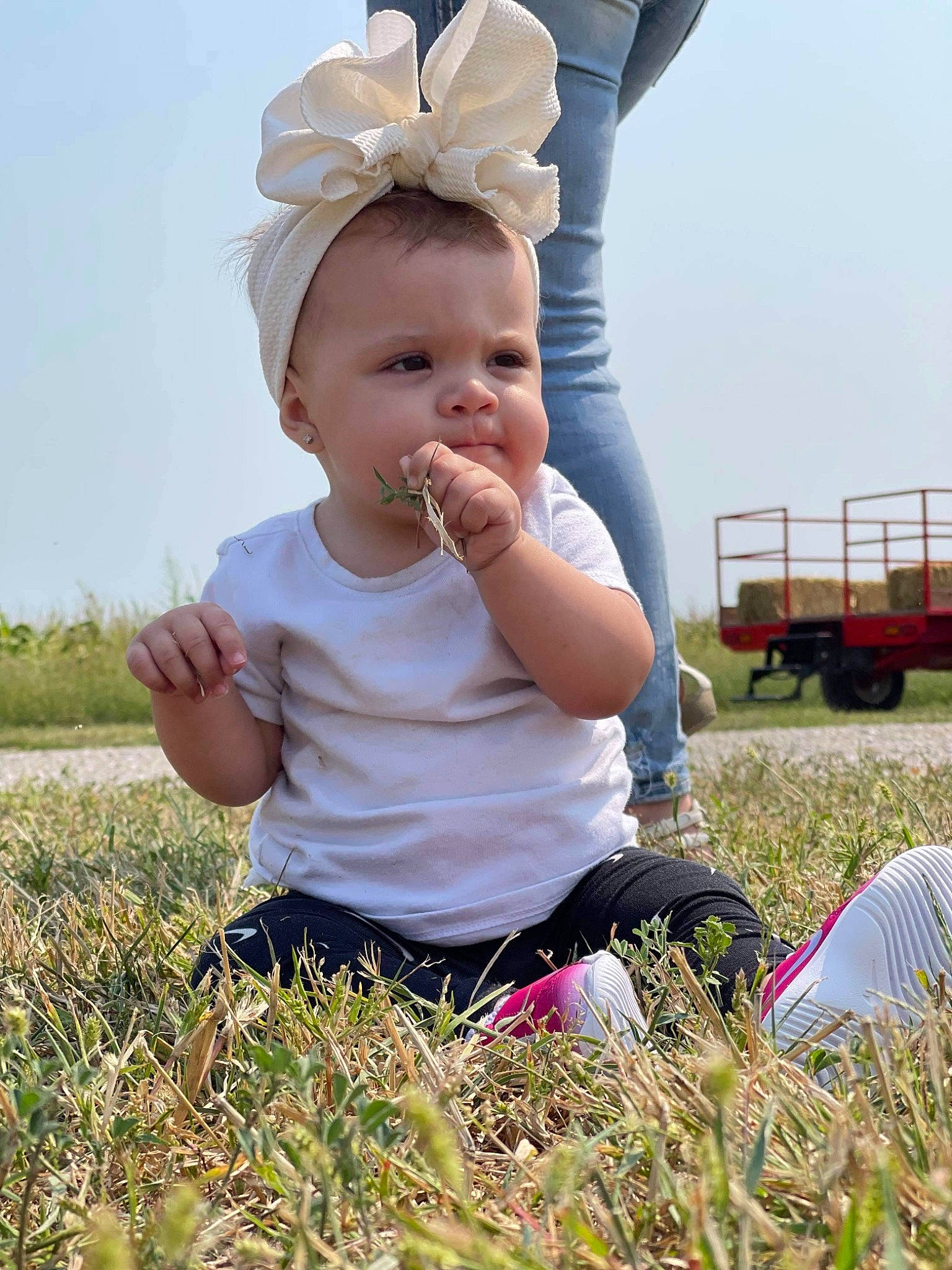 Skylynn is registered to the contest to win money with this photo: baby, baby_toddler_clothing, child, fashion_accessory, fun, grass, grassland, happy, hat, meadow, people_in_nature, person, plant, prairie, sitting, sky, summer, sun_hat, tire, toddler