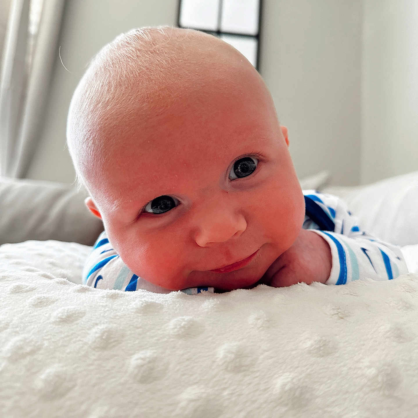 Bensen is registered to the contest to win money with this photo: baby, bed, bedroom, blanket, bodypart, couch, cushion, face, finger, furniture, hand, happy, head, indoors, newborn, person, photography, portrait, room, smile