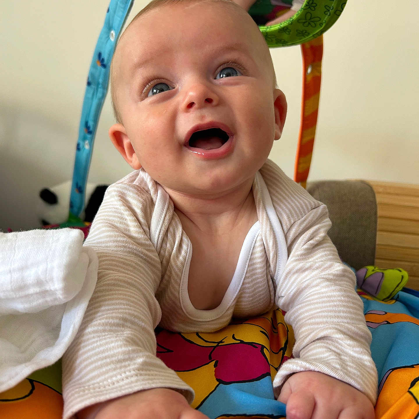 Benn is registered to the contest to win money with this photo: baby, blanket, child, clothing, colorful, cute, expression, fabric, face, hand, happy, head, indoor, infant, person, play_mat, smiling, toddler, toy, young_child