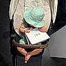 Michelle is registered to the contest to win money with this photo: toddler, stroller, baby, hat, shopping_bag, dior, indoor, footwear, clothing, child, luxury, seat, person, modern, floor, hand, foot, accessory, beads, relaxing