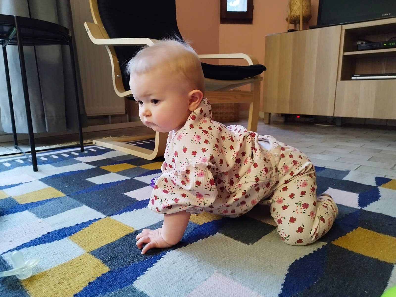 Maëva participe au concours pour gagner de l'argent avec cette photo : baby, baby_toddler_clothing, cabinetry, carpet, chair, child, floor, flooring, fun, hardwood, joint, laminate_flooring, pattern, person, room, sitting, sleeve, standing, television, toddler