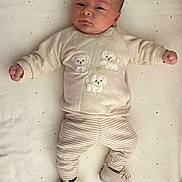 Sanad participe au concours pour gagner de l'argent avec cette photo : baby, infant, clothing, lying_down, blanket, face, expression, footwear, pajamas, cute, indoors, child, soft_texture, pattern, knit, person, sleepwear, newborn, resting, cozy