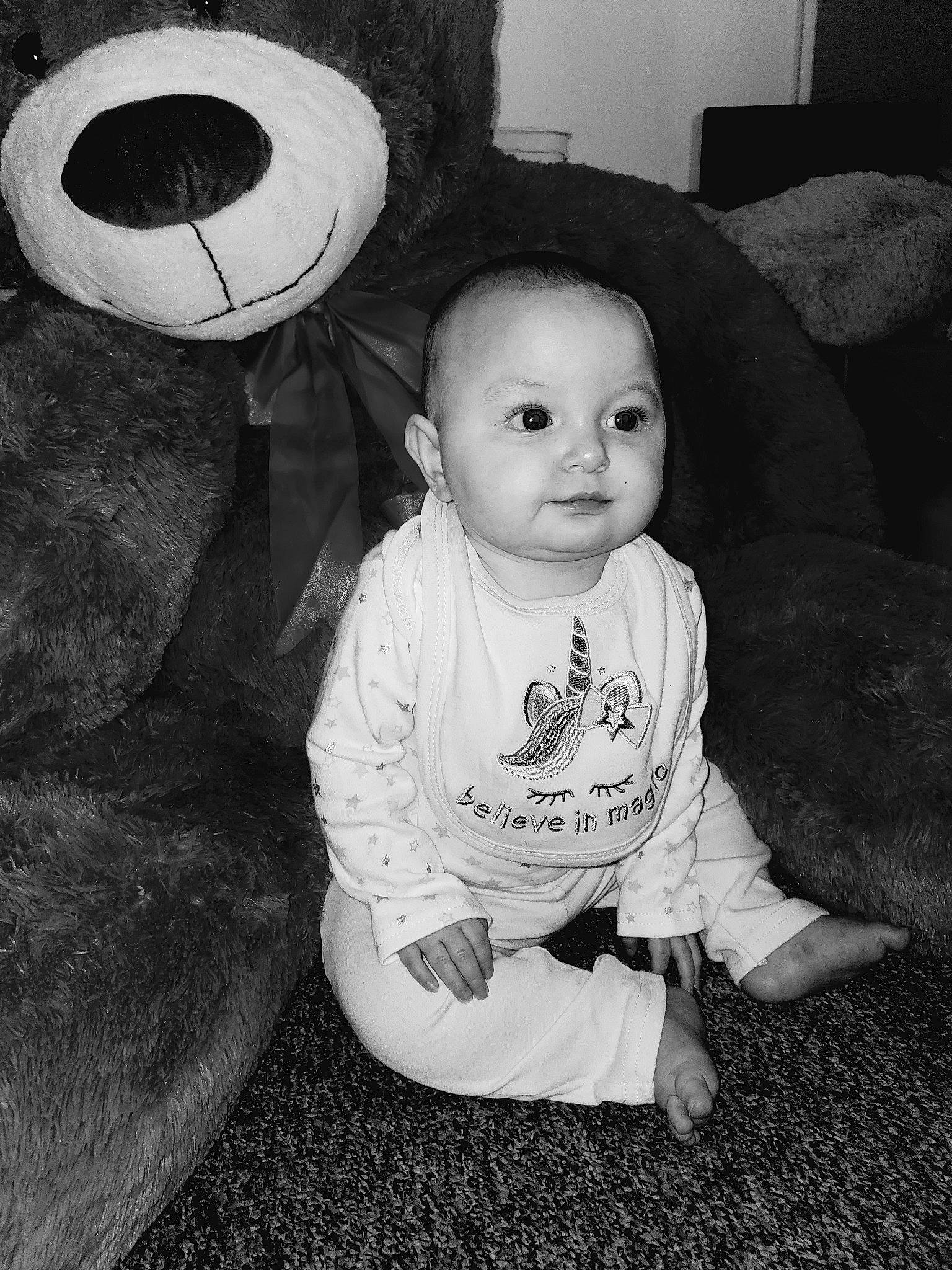 Aspen is registered to the contest to win money with this photo: baby, black, black_and_white, cheek, child, eye, face, head, iris, monochrome, monochrome_photography, person, photograph, photography, sitting, smile, snapshot, stock_photography, style, toddler