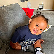 Zyniya is registered to the contest to win money with this photo: baby, child, toddler, smiling, sitting, couch, sofa, portrait, indoor, home, face, person, clothing, socks, shorts, shirt, furniture, happy, cozy, photograph