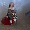 Samuel a rejoint le concours — aidez-le/la à gagner de superbes lots ! child, toddler, tricycle, toy, indoor, motion_blur, floor, smiling, curly_hair, sneakers, clothing, play, fun, happy, person, red, white, gray, concrete, blur