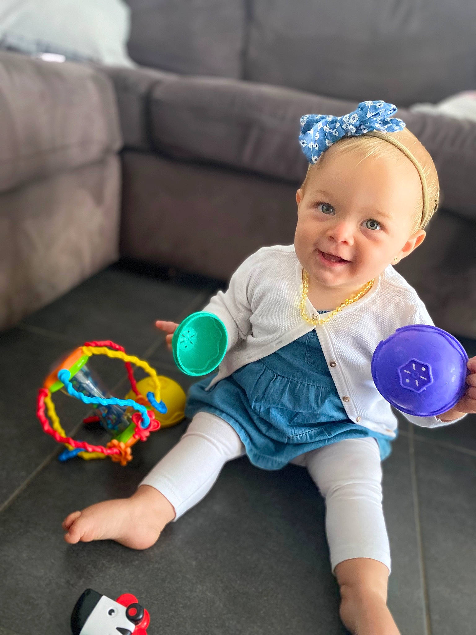 Lya participe au concours pour gagner de l'argent avec cette photo : baby, baby_playing_with_toys, baby_toddler_clothing, blue, child, couch, electric_blue, fun, happy, human_leg, joy, leisure, party_supply, person, sitting, smile, sock, sports_toy, toddler, toy