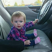 Summer joined the competition — help win amazing prizes! baby, blue_eyes, car_interior, casual_clothing, child, cute, daytime, expression, front_seat, hand, infant, leather_seat, looking_at_camera, passenger, pink_socks, plaid_shirt, portrait, seat, steering_wheel, window