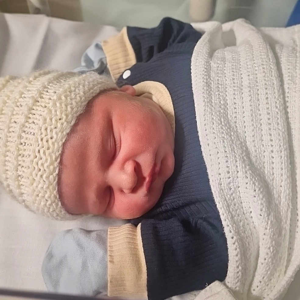 Arley is registered to the contest to win money with this photo: baby, bassinet, blanket, child, clothing, cozy, cute, hospital, indoor, infant, knit_hat, newborn, peaceful, person, portrait, resting, sleeping, soft_lighting, toddler, wrapped