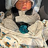 Arley is registered to the contest to win money with this photo: newborn, baby, sleeping, infant, hat, gray_hat, pacifier, blanket, swaddled, car_seat, portrait, cozy, clothing, mittens, face, closed_eyes, indoors, photography, soft_blanket, resting