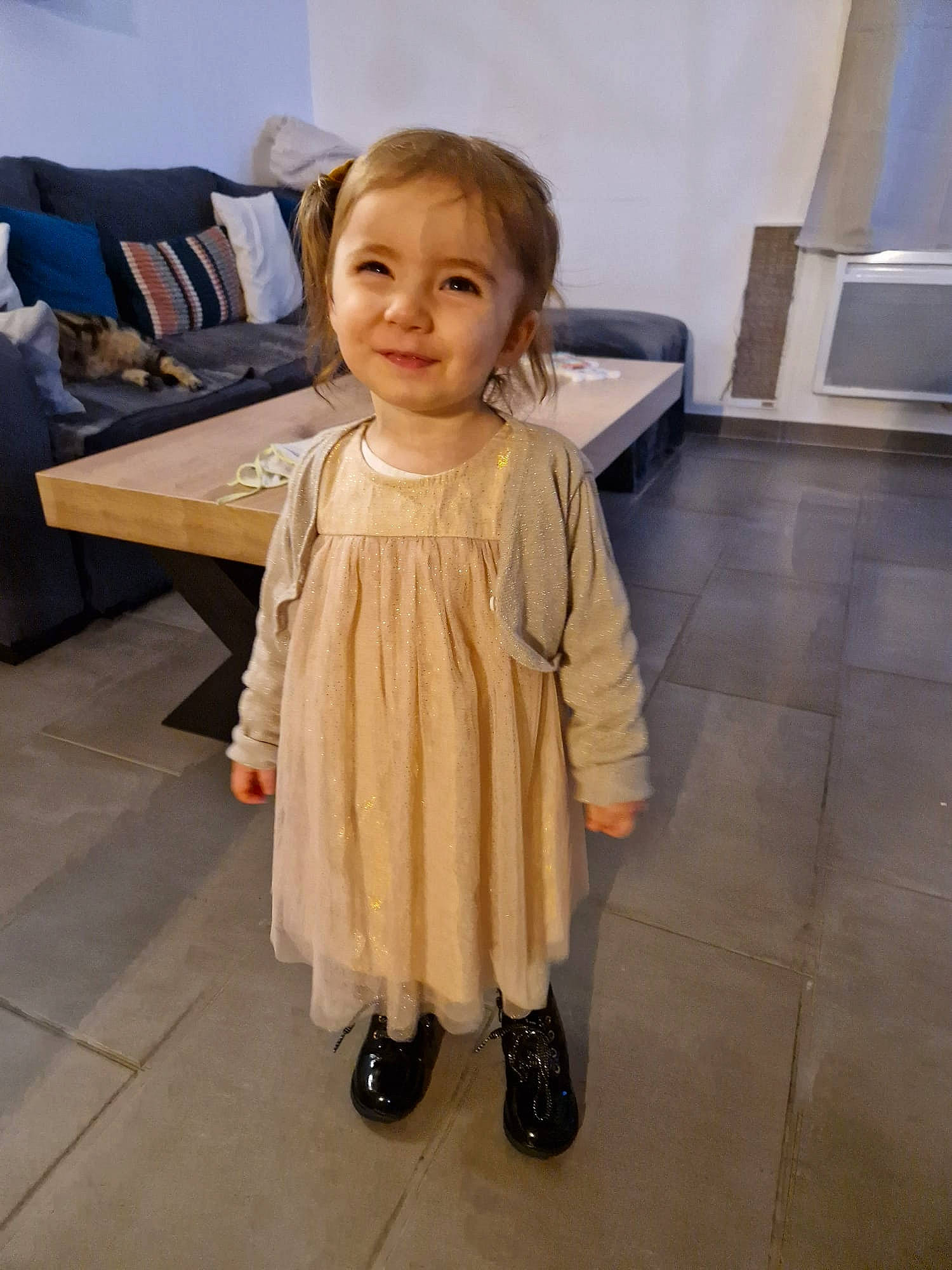 Leïna participe au concours pour gagner de l'argent avec cette photo : baby, baby_toddler_clothing, chair, cheek, child, dress, fashion_design, floor, flooring, formal_wear, fun, happy, hardwood, joy, pattern, person, room, sitting, sleeve, smile