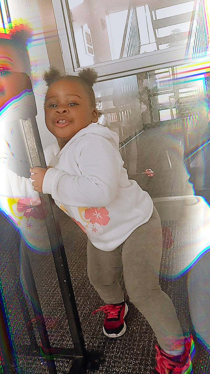 Kylah is registered to the contest to win money with this photo: automotive_design, baby, baby_products, car_seat, child, fun, happy, human_leg, joy, knee, leisure, outerwear, person, recreation, room, sitting, smile, sock, standing, t_shirt