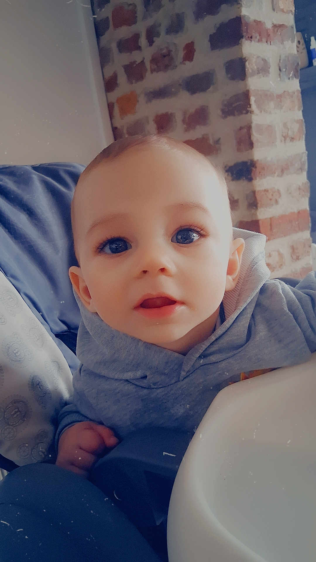 Adriano participe au concours pour gagner de l'argent avec cette photo : baby, child, face, eyes, hoodie, high_chair, indoor, brick_wall, furniture, person, portrait, cute, infant, young_child, clothing, hand, mouth, expression, cozy, home