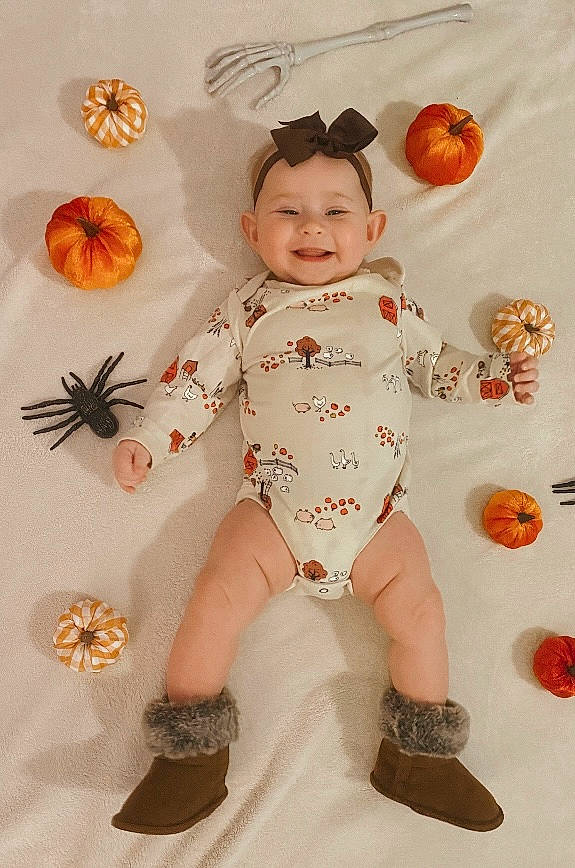 Raelynn joined the competition — help win amazing prizes! baby, baby_toddler_clothing, baby_toys, calabaza, child, foot, happy, human_leg, insect, joy, orange, pattern, peach, person, pumpkin, room, sitting, sleeve, smile, sock