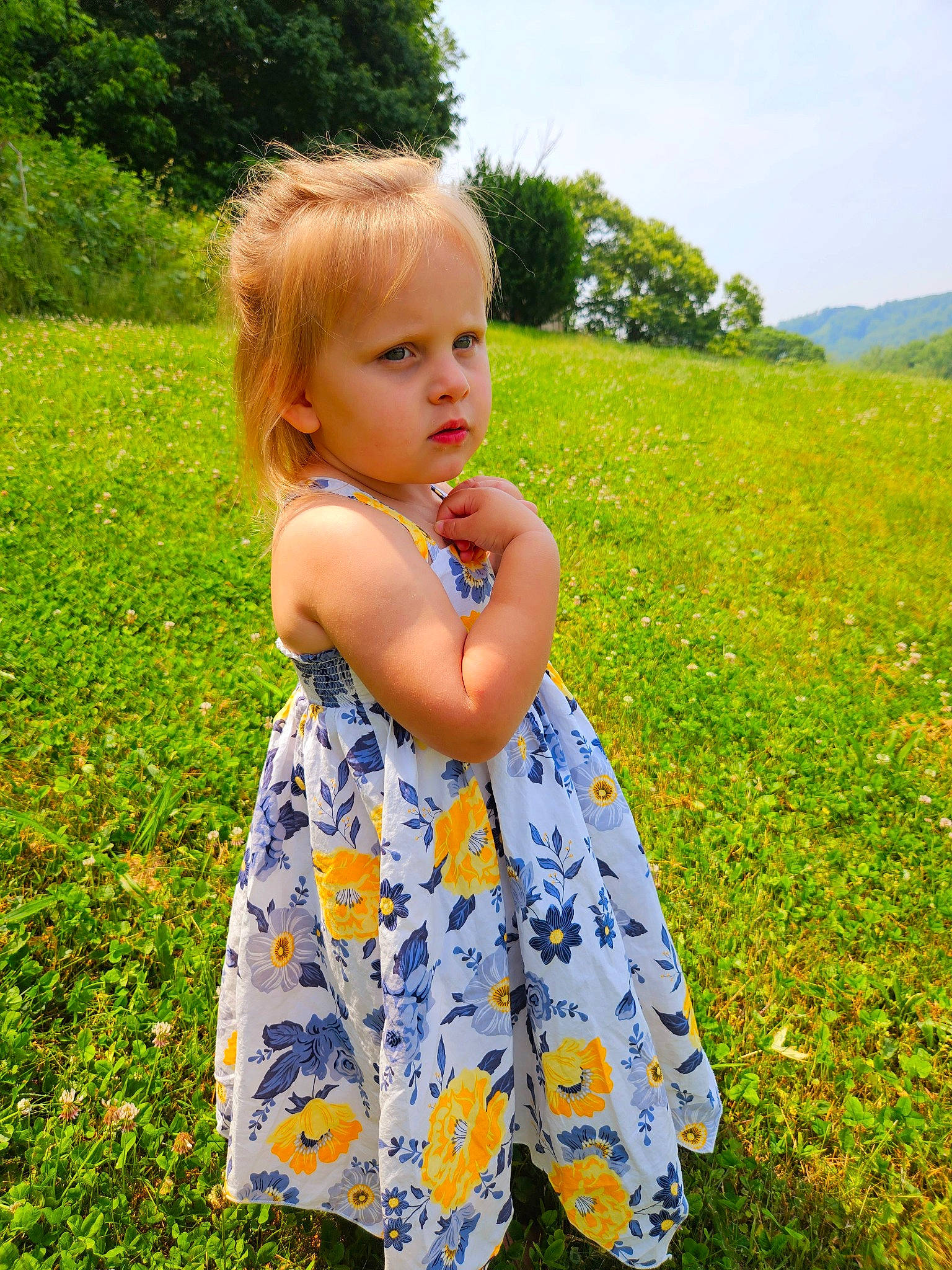 Corinne is registered to the contest to win money with this photo: baby_toddler_clothing, blond, child, day_dress, dress, flower, fun, grass, grass_family, grassland, happy, meadow, one_piece_garment, people_in_nature, person, plant, prairie, sky, sunlight, toddler