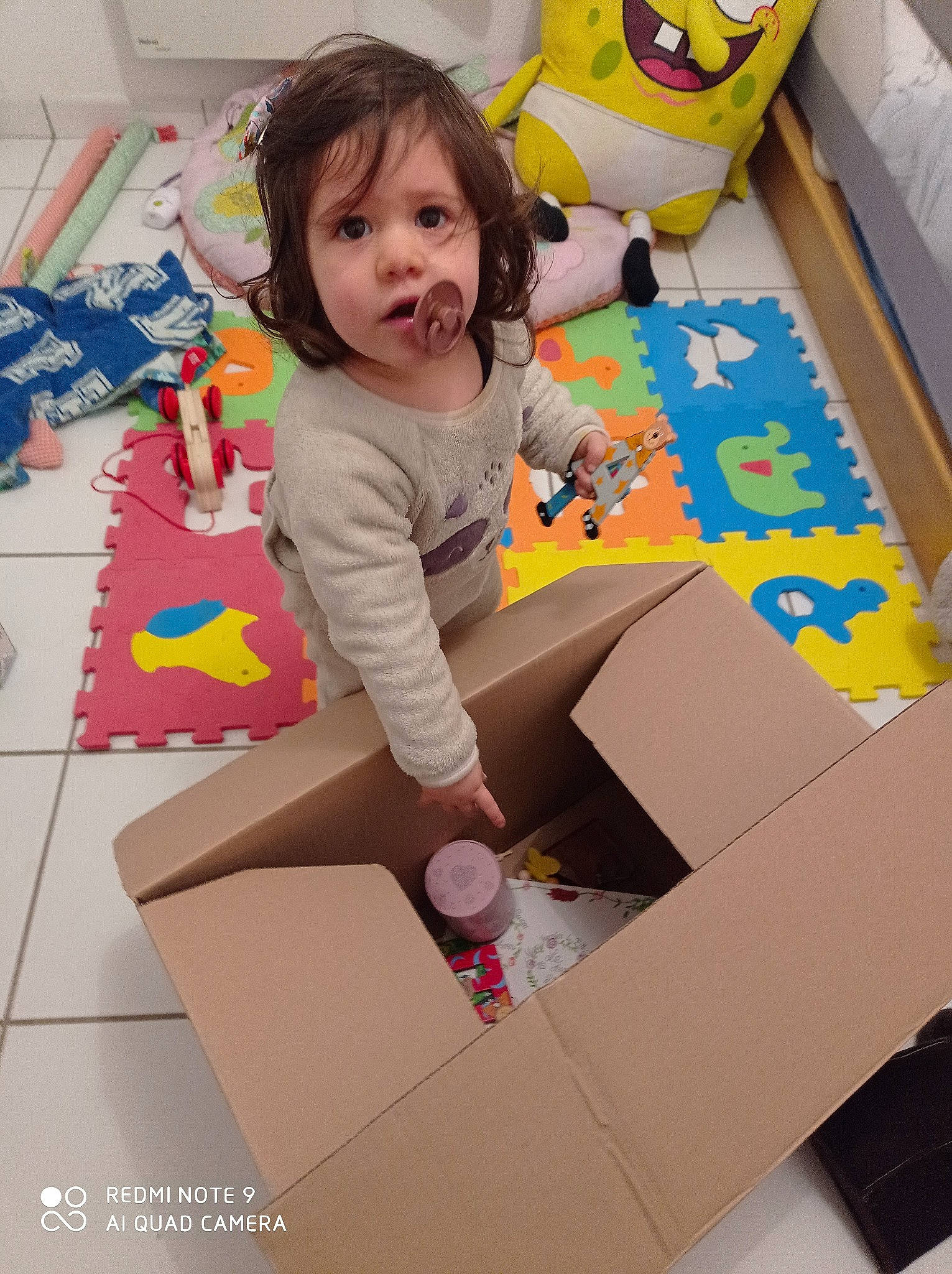 Jade participe au concours pour gagner de l'argent avec cette photo : baby, box, cardboard, carton, child, design, floor, flooring, fun, packaging_and_labeling, packing_materials, paper_product, person, play, product, room, shipping_box, sitting, sock, surprise