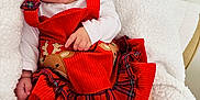 Génesis is registered to the contest to win money with this photo: baby, infant, red_dress, reindeer, plaid, white_blanket, cozy, cute, smiling, tongue_out, child, socks, soft_texture, indoor, portrait, happy, holiday, festive, person, seated