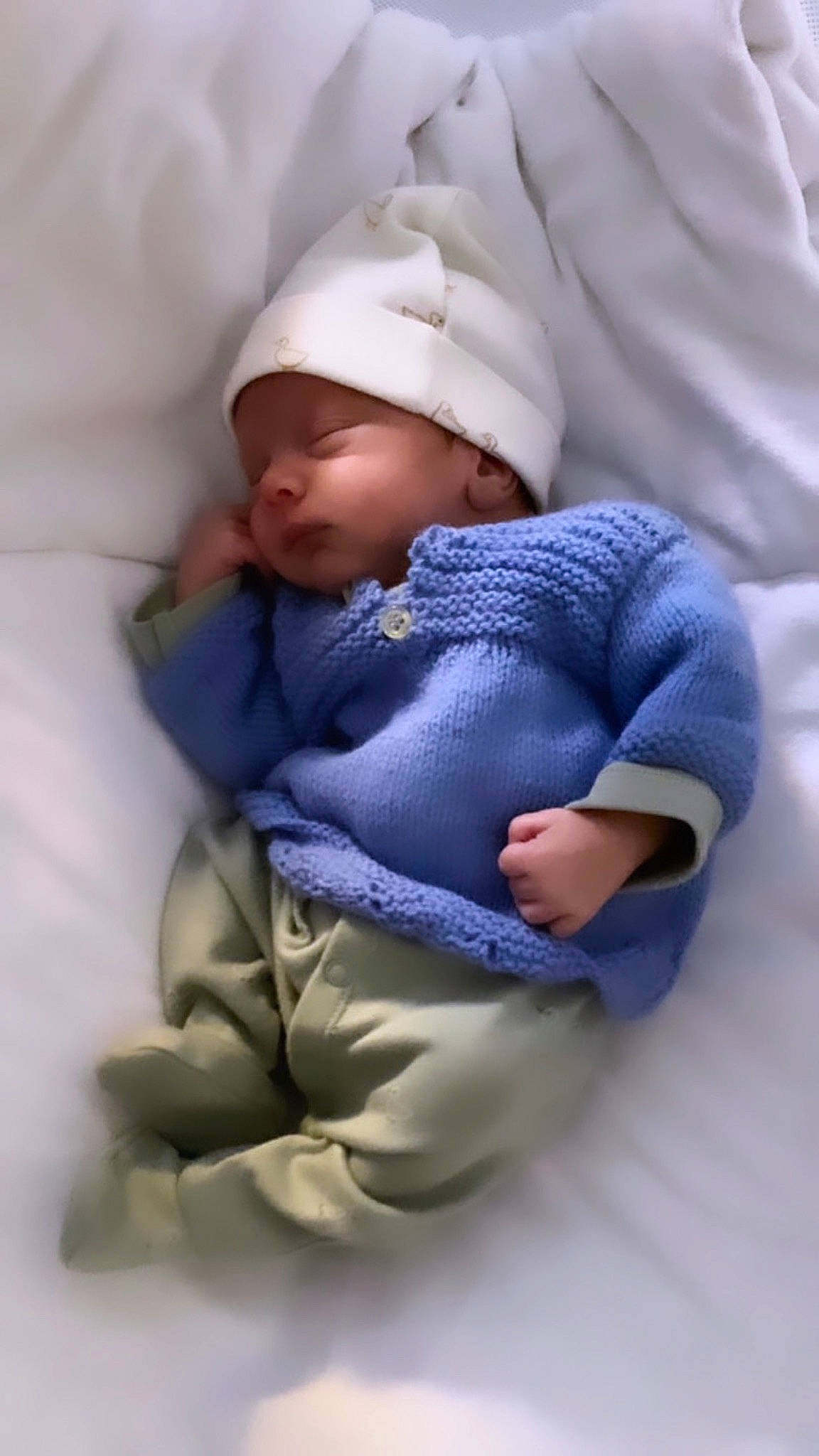 Elias participe au concours pour gagner de l'argent avec cette photo : baby, baby_products, baby_sleeping, baby_toddler_clothing, beanie, cap, cheek, child, comfort, electric_blue, finger, foot, headwear, knit_cap, person, purple, sitting, skin, sleeve, textile