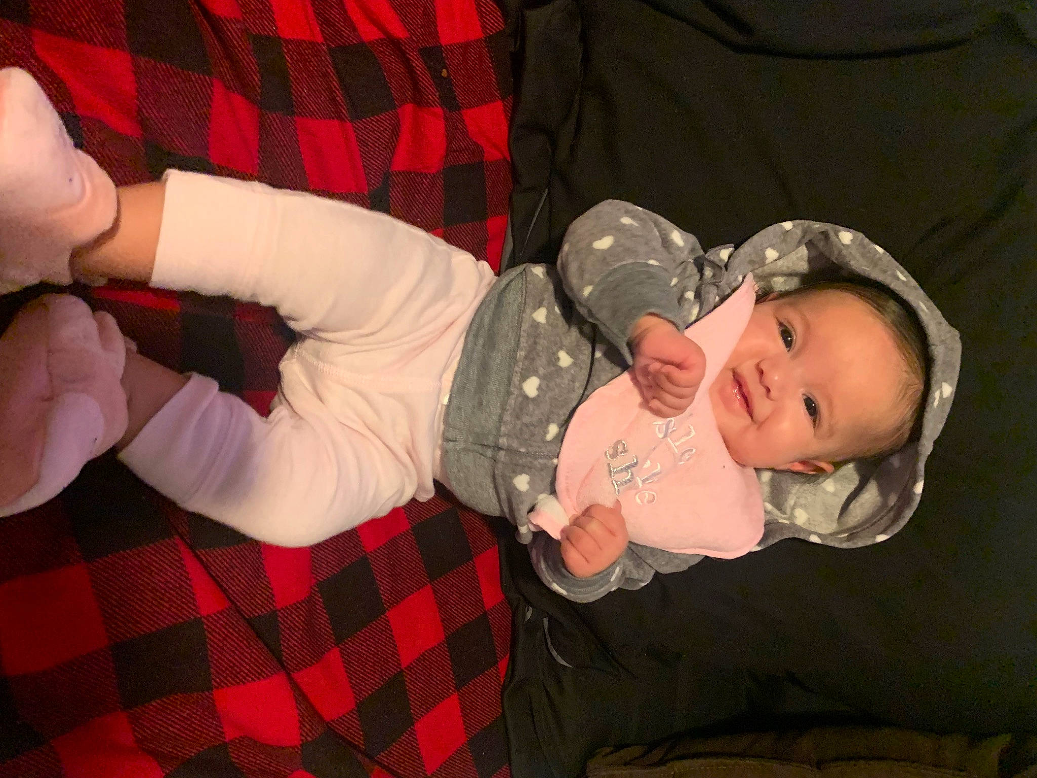 Naylani joined the competition — help win amazing prizes! baby, baby_toddler_clothing, child, comfort, design, finger, fun, gesture, lap, pattern, person, plaid, product, red, sitting, skin, sleeve, sock, tartan, thumb