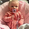 baby, infant, pink_clothing, pacifier, blanket, crib, indoor, cute, child, portrait, sleepwear, baby_girl, cozy, soft_toys, toddler, hand, face, sitting, comfortable, curious