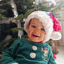 baby, celebration, child, christmas, cute, face, festive, gift, green_clothing, happy, holiday, holiday_season, indoor, minnie_mouse, portrait, present, santa_hat, seasonal, smiling, young_child