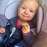 Eden a rejoint le concours — aidez-le/la à gagner de superbes lots ! toddler, child, car_seat, messy_face, bread, snack, blue_eyes, sweater, seatbelt, cute, indoor, portrait, young_child, clothing, happy, baby, person, seat, smile, hand