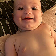 Eden a rejoint le concours — aidez-le/la à gagner de superbes lots ! baby, bare_chest, bed, blanket, cheeks, child, closeup, cute, face, happy, indoors, infant, lying_down, person, pillow, portrait, relaxing, skin, smiling, young_child