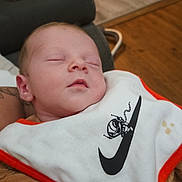 Djino participe au concours pour gagner de l'argent avec cette photo : baby, newborn, sleeping, bib, clothing, hand, person, indoor, glasses, couch, wooden_floor, cozy, closeup, infant, peaceful, soft_lighting, face, cute, resting, home