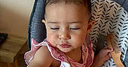 Jade joined the competition — help win amazing prizes! toddler, child, high_chair, hair_clips, comb, pink_clothing, indoor, table, food, baby, person, cute, seat, jewelry, expression, hand, face, hair, eating, home