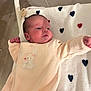newborn, baby, infant, blanket, heart_pattern, onesie, sleepwear, cute, soft_texture, lying_down, stretching, indoors, baby_bed, peaceful, adorable, child, portrait, toddler, warm, comfort