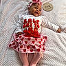 baby, infant, smiling, headband, strawberry, pink, red, white, blanket, plush, clothing, tights, bow, portrait, lying_down, cute, happy, six_months, wooden_plaque, texture