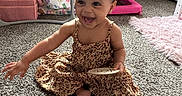 Paris is registered to the contest to win money with this photo: toddler, child, smiling, carpet, dress, toy, indoor, hair_accessories, furniture, playroom, pink, floor, happy, baby, person, curtains, cabinet, fabric, reaching, home