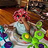 Paris joined the competition — help win amazing prizes! baby, child, sunglasses, hat, activity_center, toy, indoor, floor, furniture, living_room, person, playful, colorful, seat, cute, smiling, hand, clothing, decor, home