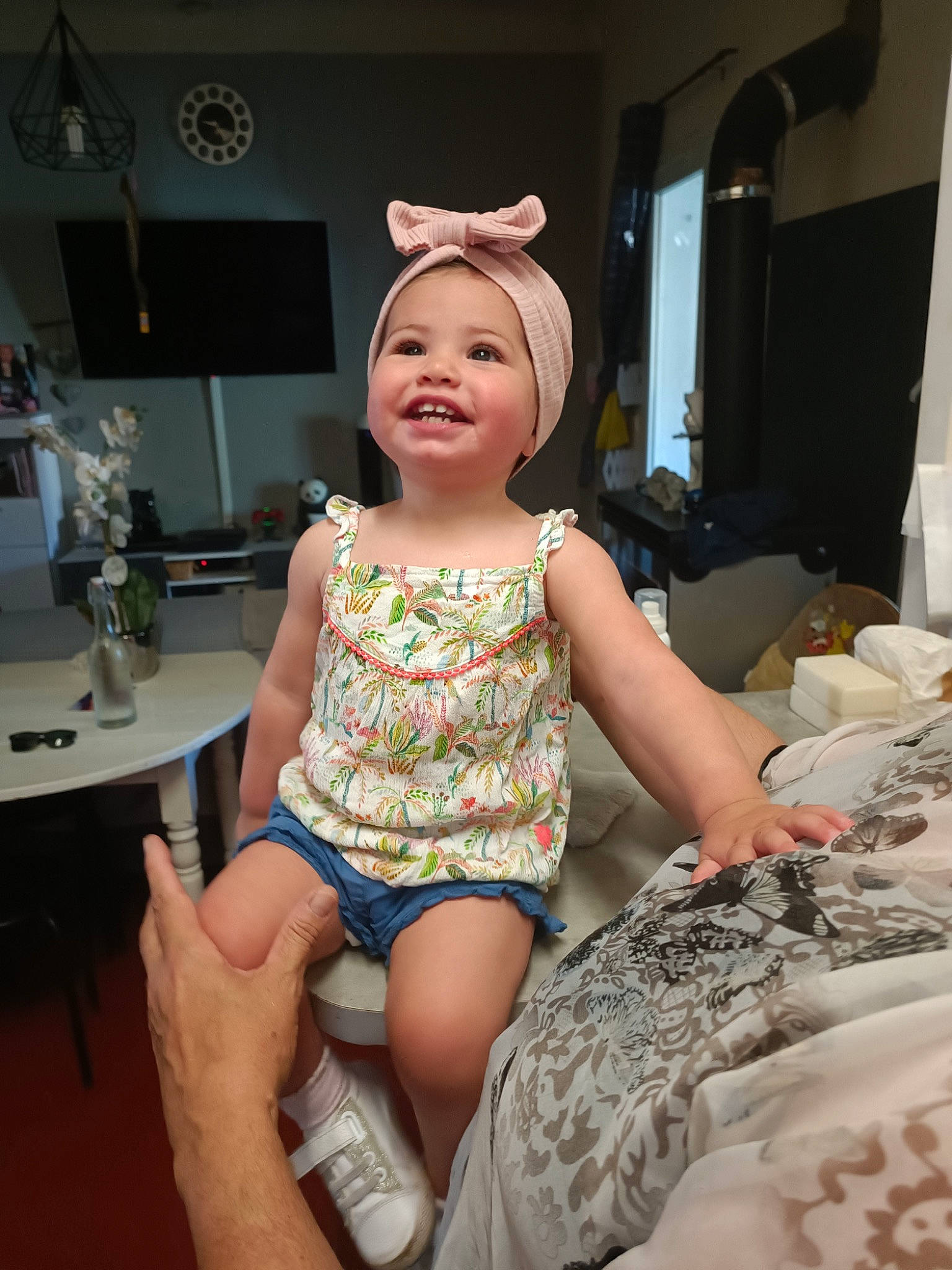 Giulia participe au concours pour gagner de l'argent avec cette photo : chair, child, fashion_design, floor, flooring, foot, fun, hairstyle, happy, headwear, human_leg, joy, knee, leg, pattern, person, room, sitting, smile, table