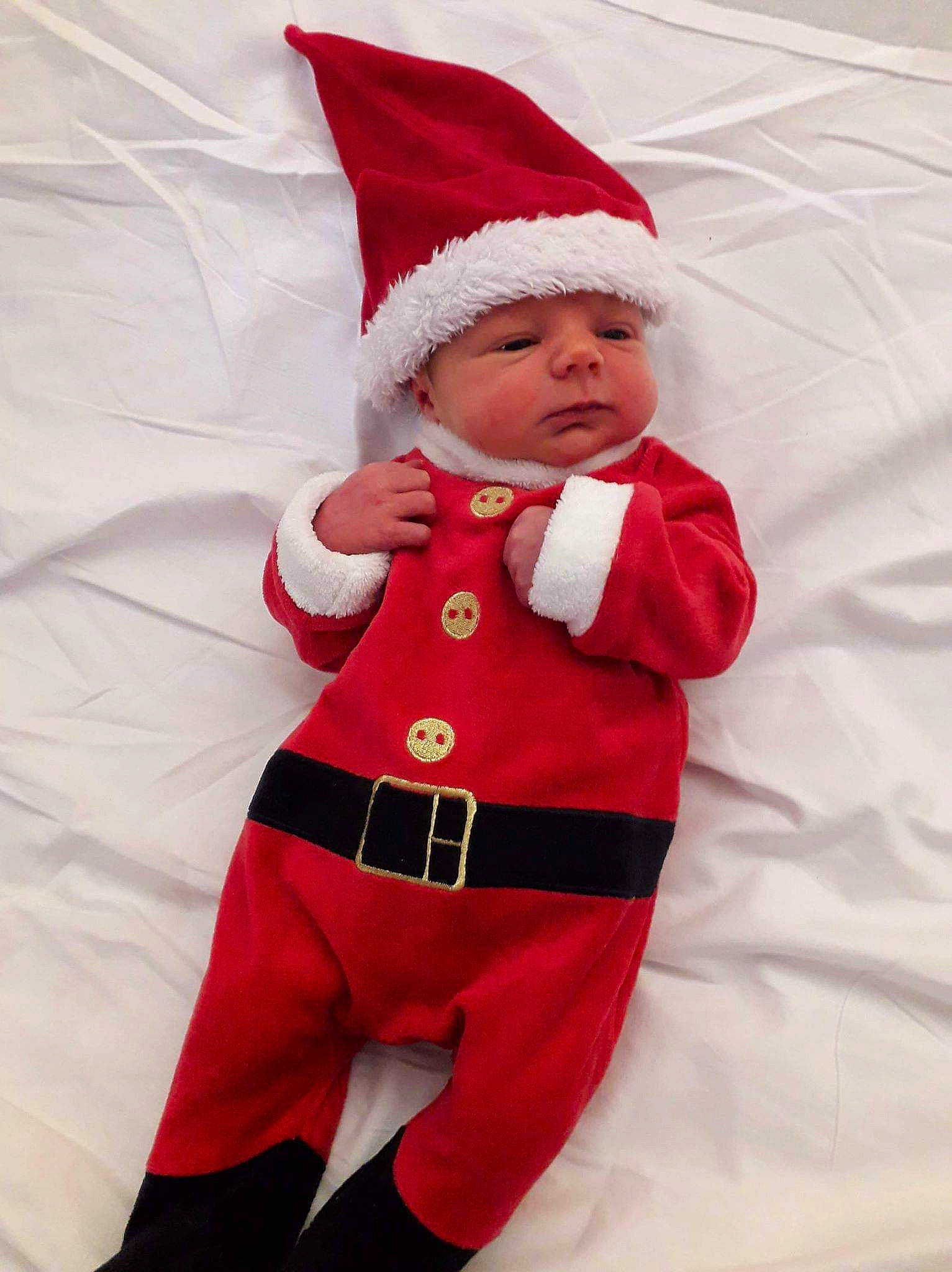 Léopold participe au concours pour gagner de l'argent avec cette photo : child, christmas, christmas_eve, costume, fictional_character, headwear, holiday, person, red, santa_claus, smile, toddler