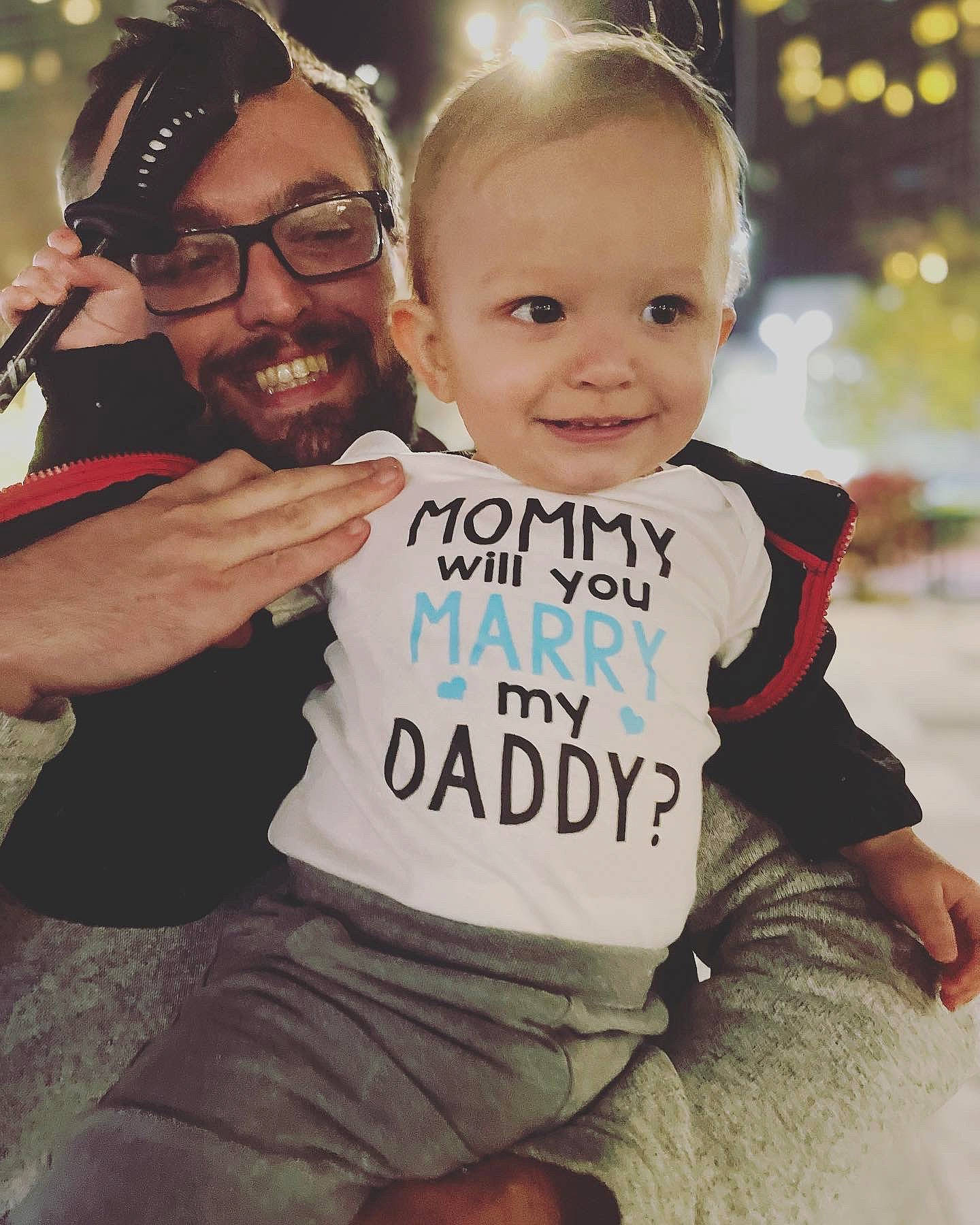 Carter is registered to the contest to win money with this photo: baby_toddler_clothing, eye, face, facial_expression, flash_photography, fun, gesture, glasses, hair, hairstyle, happy, head, human, interaction, joy, mammal, person, skin, sleeve, smile