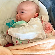 Eva a rejoint le concours — aidez-le/la à gagner de superbes lots ! baby, blanket, pacifier, smile, infant, soft_toy, cushion, clothing, face, head, sleepwear, comfort, resting, indoors, cute, child, newborn, fabric, bedtime, relaxation