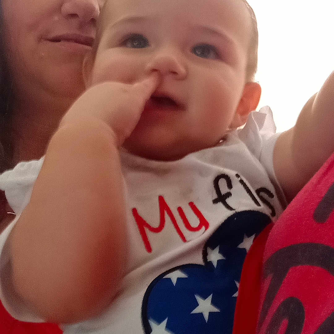 Katie is registered to the contest to win money with this photo: baby, bodypart, clothing, face, finger, flag, frown, hand, happy, head, laughing, mouth, newborn, person, photography, portrait, sad, selfie, smile, t_shirt